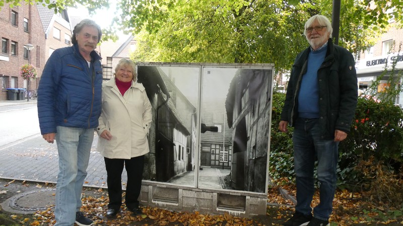 Der Stromkasten mit dem Foto der Gasse zum ehemaligen Domhof, der Ende der 1960er-Jahre abgerissen wurde. Von rechts nach links: Gottfried Forstmann (1. Vorsitzender des Verkehrsvereins Werne), Heidelore Fertig-Möller (2. Vorsitzende) und Roland Neijenhof